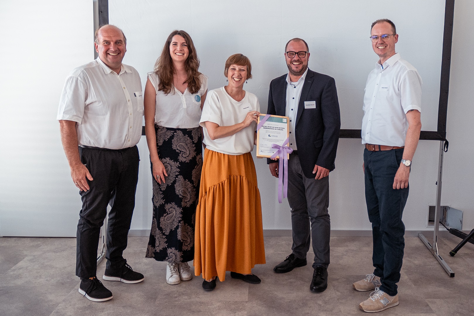 Startschuss für Startup-Hub: Martin Schmitz, Julia Amtmann, Kristina Notz, Sebastian Straubel und Florian Eckardt stehen nebeneinander. Sie präsentieren das Gründungszertifkat für das das Social-Startup-Hub Bayern, Oberfranken in Coburg.