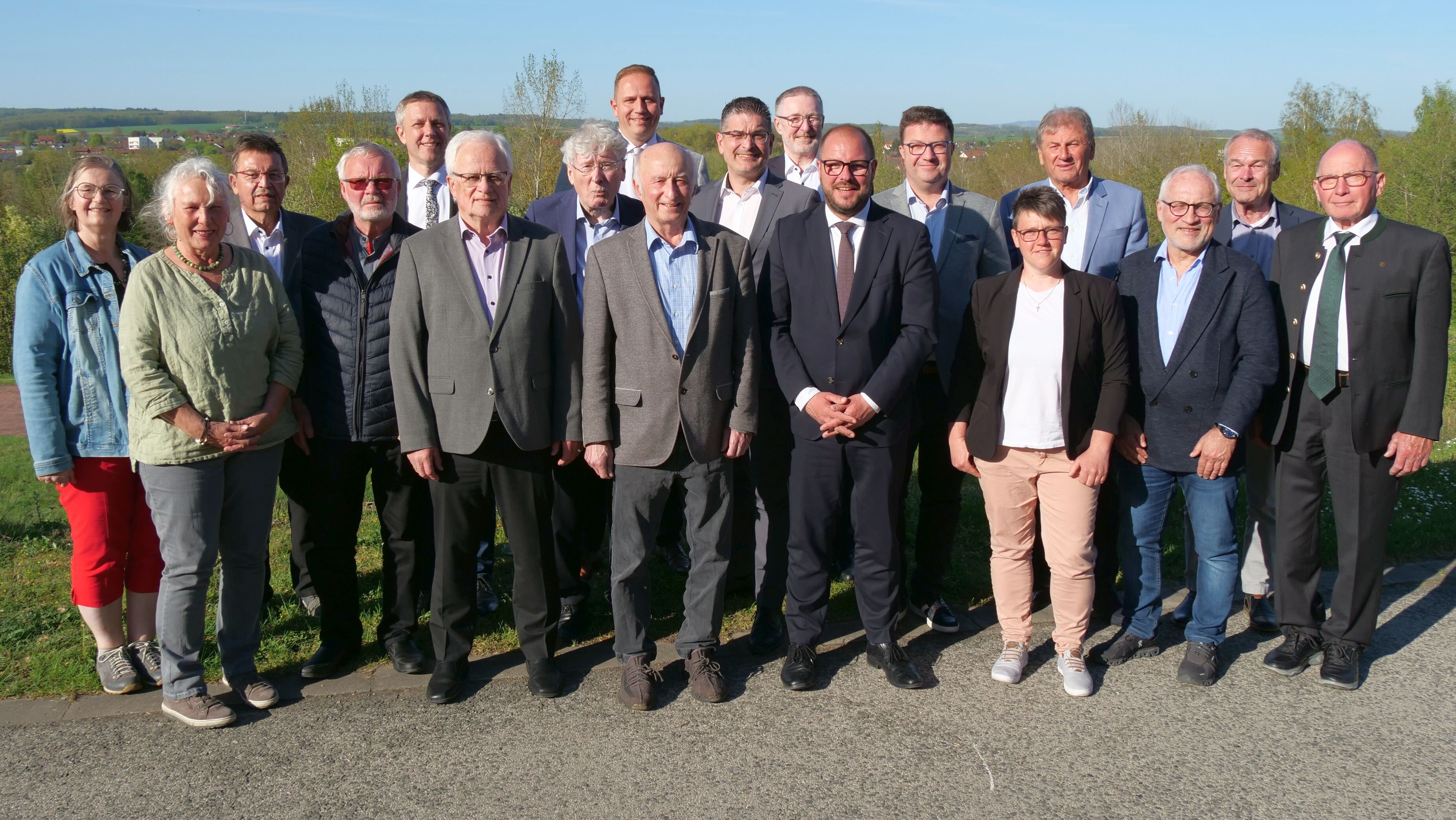 Das Gruppenbild der ausgeschiedenen Mitglieder des Kreistages. Sie stehen vor dem Kurhotel, im Hintergrund ist der weite Blick ins Coburger Land.
