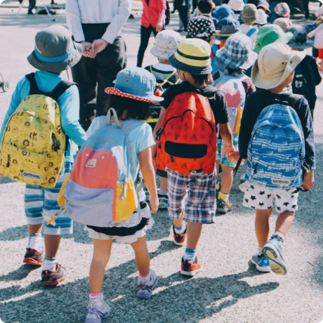 Kinder mit Rucksack laufen eine Straße entlang 