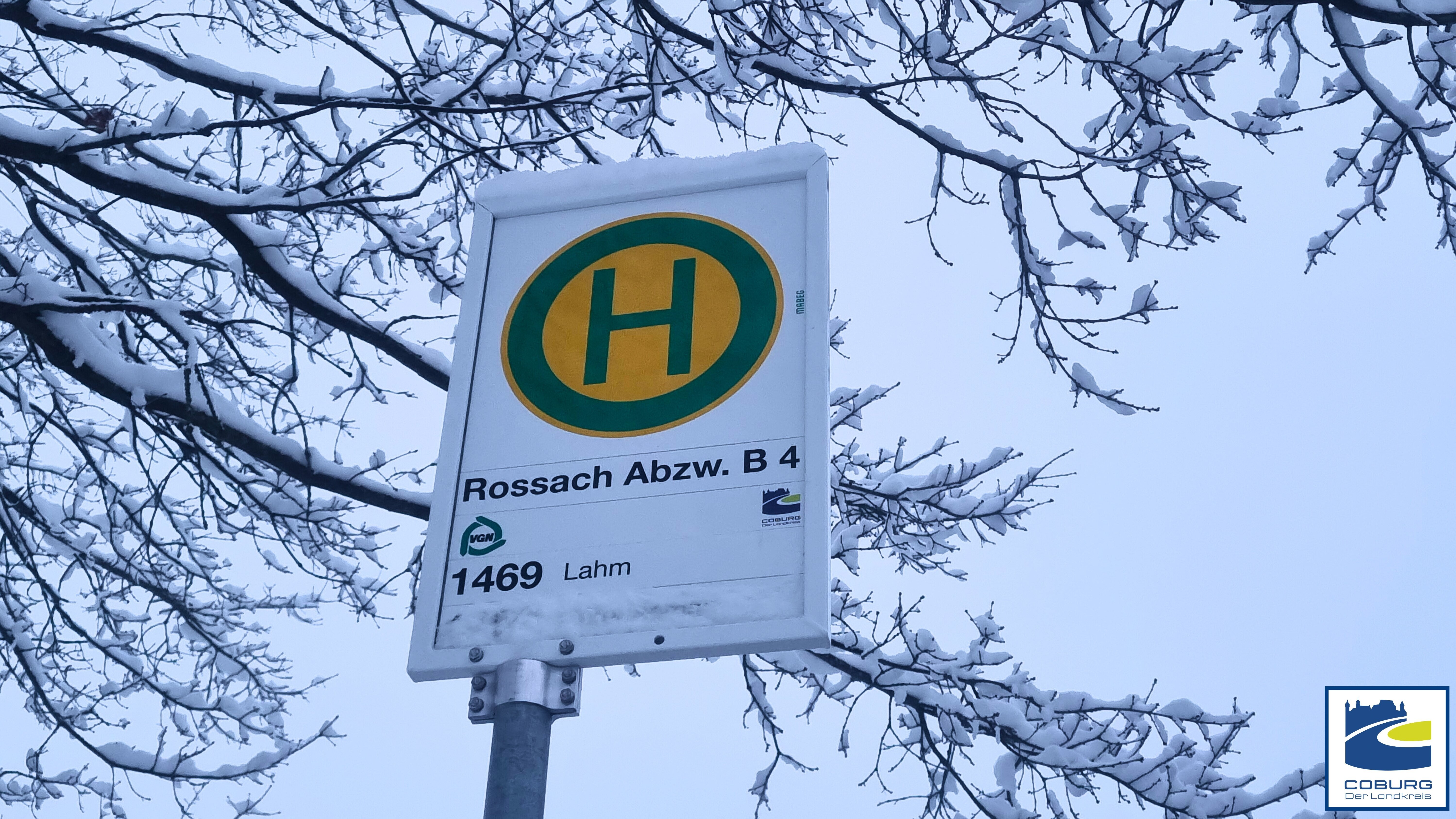 Das schneebeckte Schild der Bushaltestelle in Rossach.