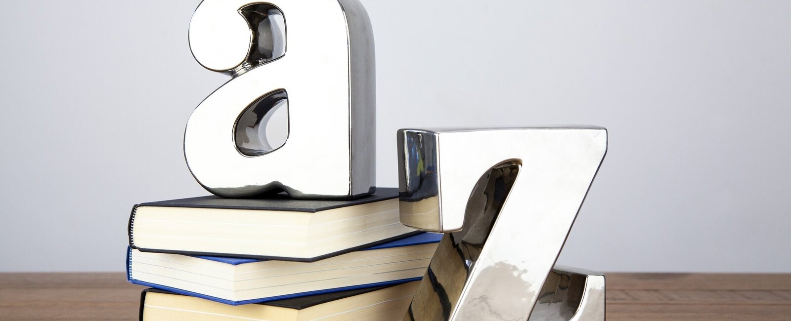 Die Buchstaben A und Z stehen neben einem Bücherstapel 