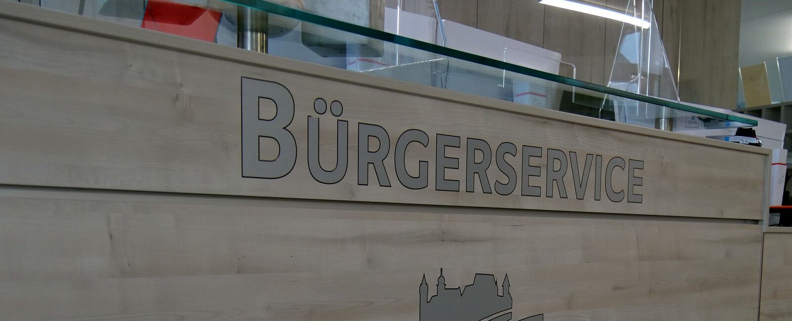 Blick auf einen Teil der Empfangstheke am Eingang des Landratsamtes mit der Aufschrift "Bürgerservice" 