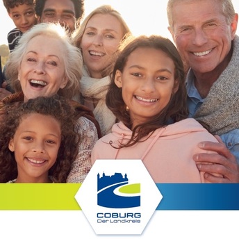 Gruppenbild mit Menschen aus verschiedenen Herkunftsländern plus Logo des Landkreises Coburg.