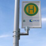 Das Schild einer Bushaltestelle: grünes H auf gelbem Untergrund mit grünem Rand.