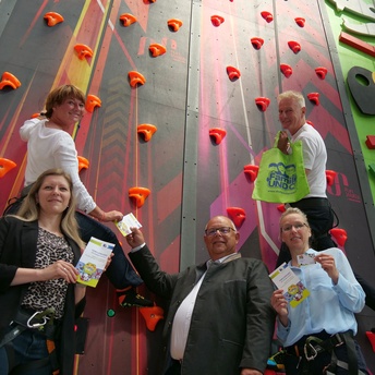 Yvonne Schnapp, Susanne Lange, Martin Stingl, Stine Michel und Lutz Lange stehen mit den Familiencards in der Hand vor einer Kletterwand in der Funtasy World in Rödental.