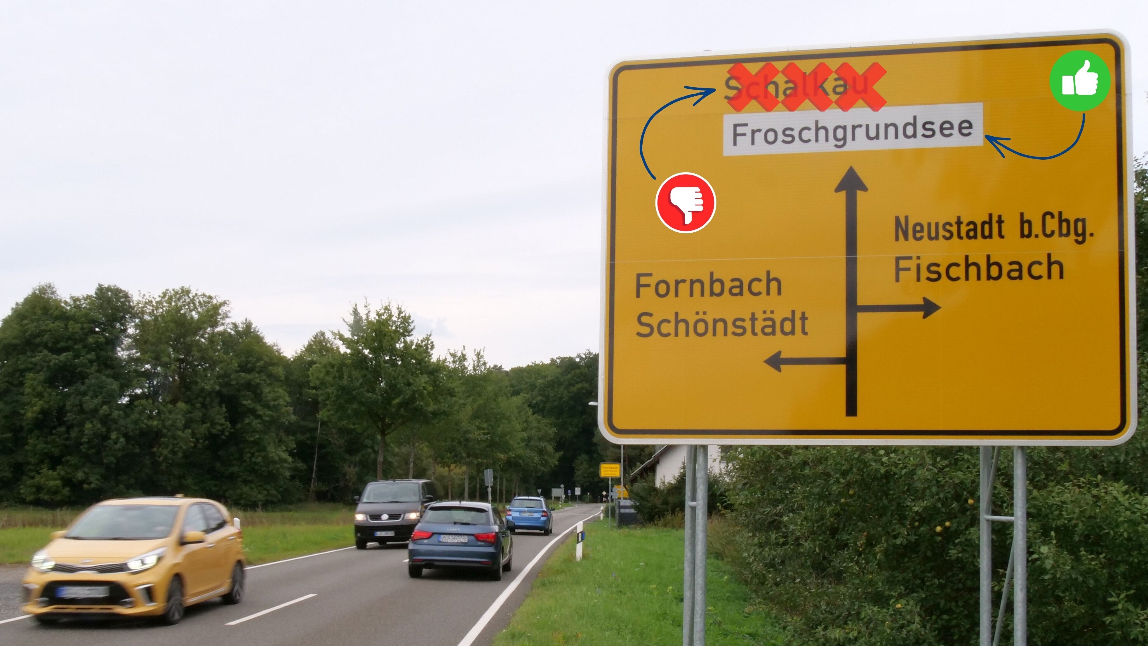 Autos fahren auf der Staatsstraße 2206. Auf dem Hinweisschild neben der Straße sind Icons eingefügt - ein Daumen nach unten steht bei Schalkau, ein Daumen nach oben beim Froschgrundsee.