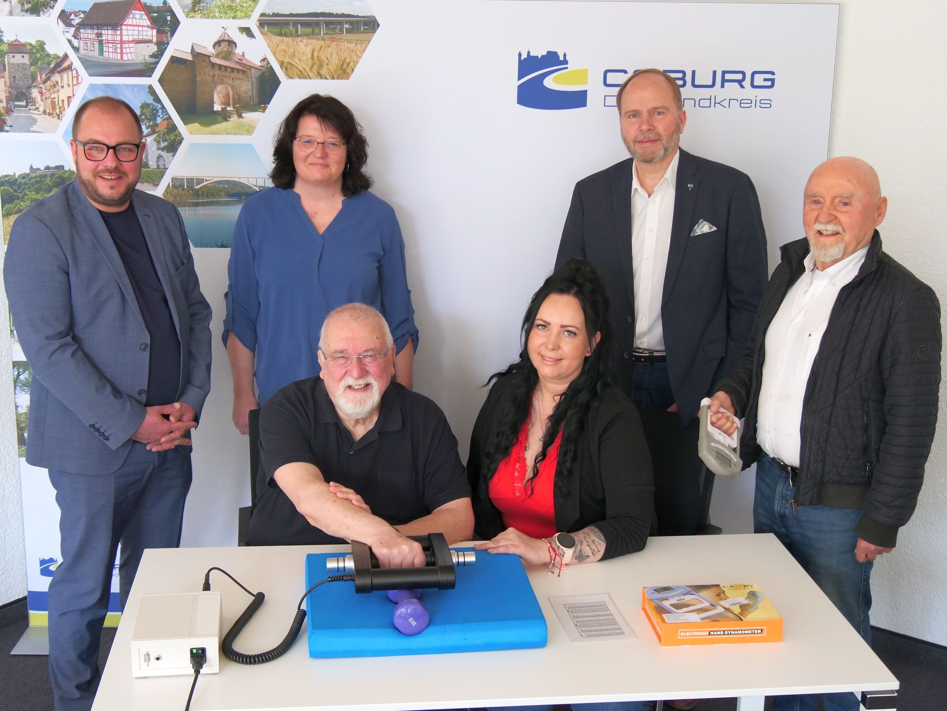 Im Vordergrund sitzen Dr. Wolfgang Hasselkus und Jasmin Röder, die eine Galileo-Hantel testen. Dahinter stehen von links Sebastian Straubel, Esther Fiedler, Bernd Reisenweber und Horst-Ludwig Weingarth.