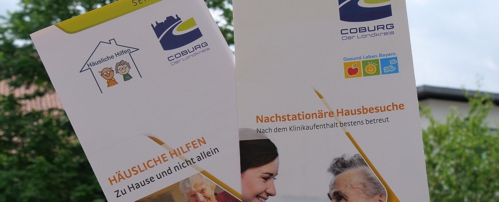 Eine Hand zeigt Broschüren aus dem Landkreis Coburg 