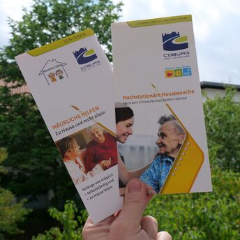 Eine Hand zeigt Broschüren aus dem Landkreis Coburg 