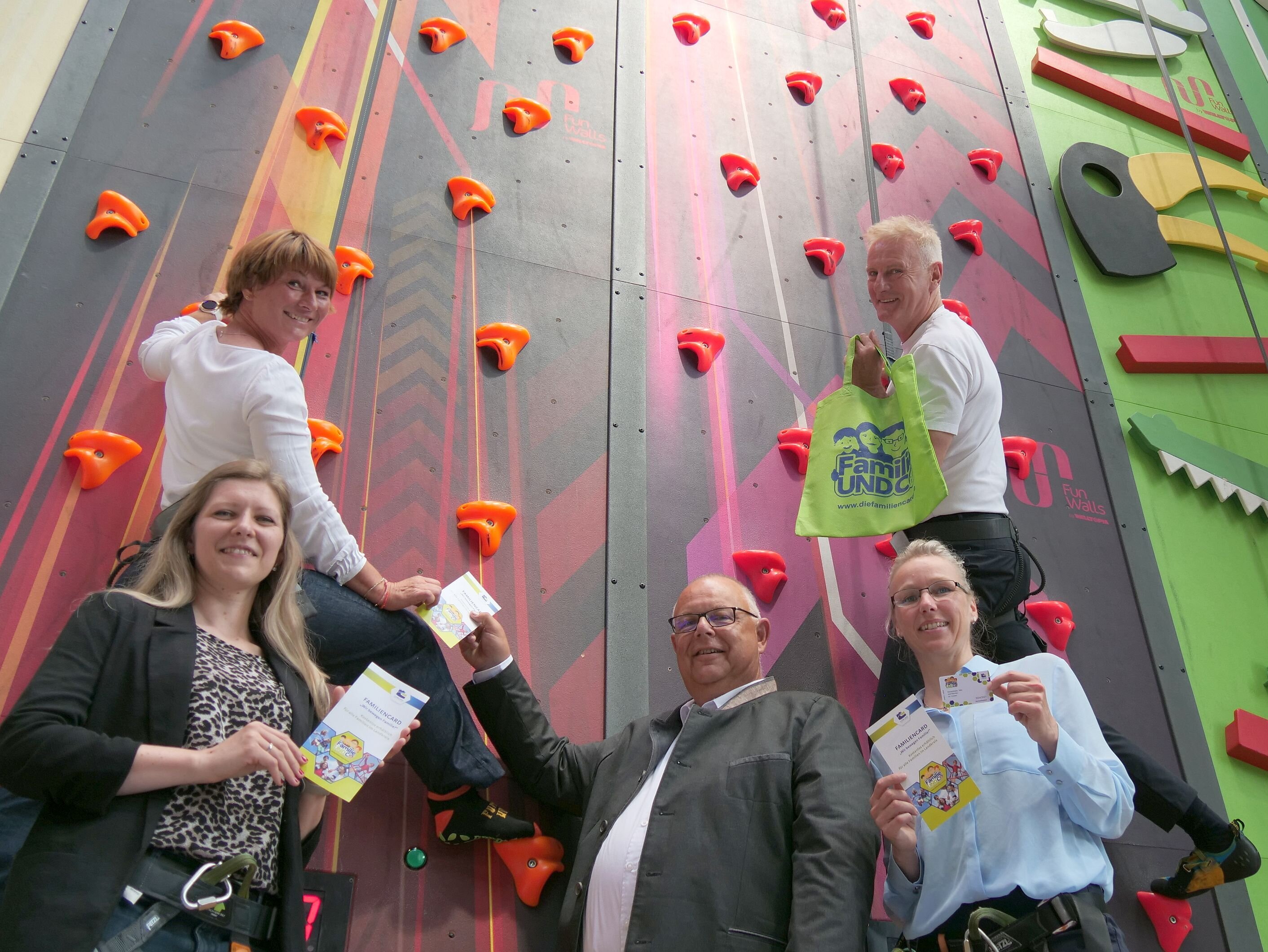 Yvonne Schnapp, Susanne Lange, Martin Stingl, Stine Michel und Lutz Lange stehen vor einer Kletterwand und haben Werbeartikel für die Familiencard des Landkreises Coburg in der Hand.