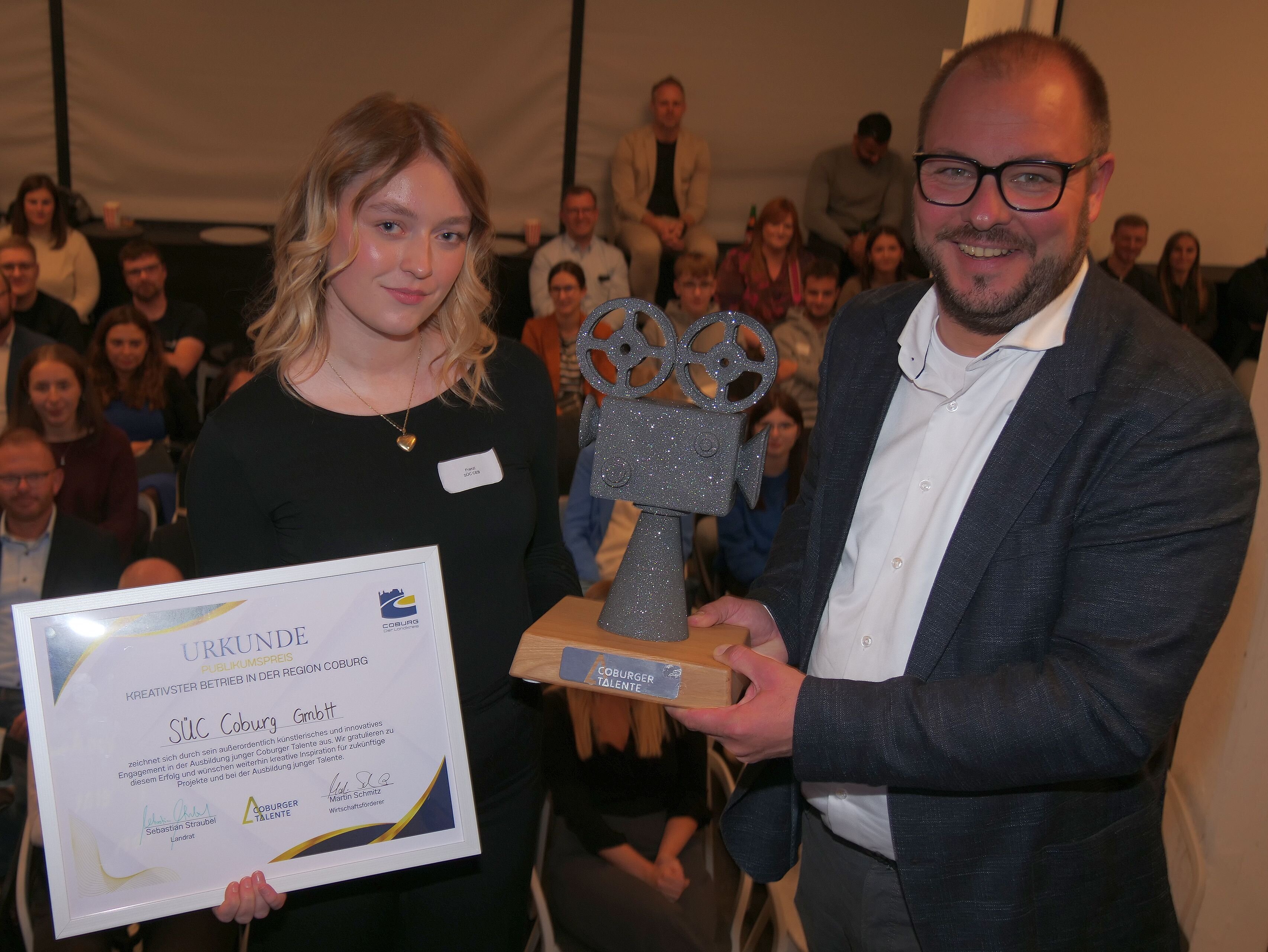 Franzi Bauersachs bekommt von Landrats Sebastian Straubel die Siegertrophäe für den Publikumspreis überreicht.