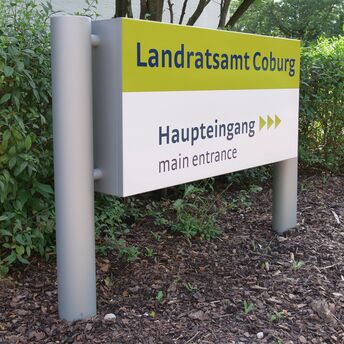 Ein Schild mit der Aufschrift "Landratsamt Coburg - Haupteingang" 