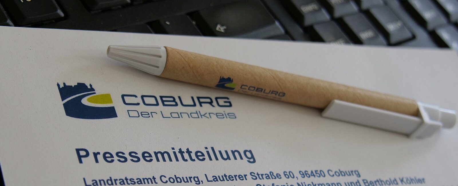Ein Blatt mit der Aufschrift "Pressemitteilung" liegt mit einem Stift auf einem Schreibtisch 
